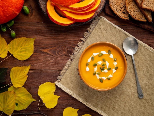 Sopa de purê de abóbora de comida de outono deixa espaço para cópia de mesa de madeira velha marrom escura