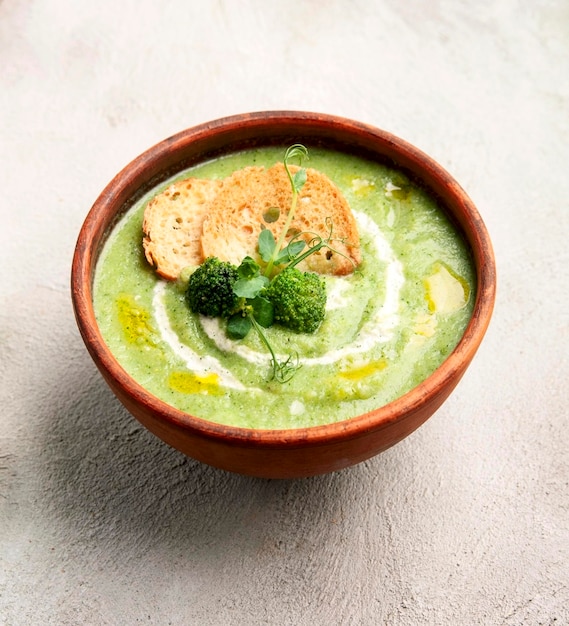 Sopa de purê de brócolis com bolachas e legumes frescos nas mesas Cozinha caseiraComida vegetariana