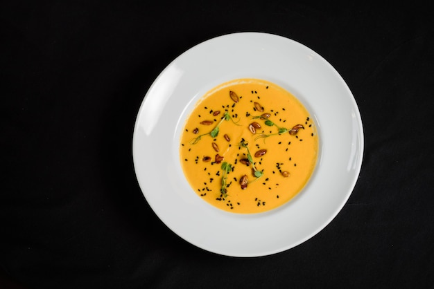 Foto sopa de purê de vegetais amarelos em prato branco