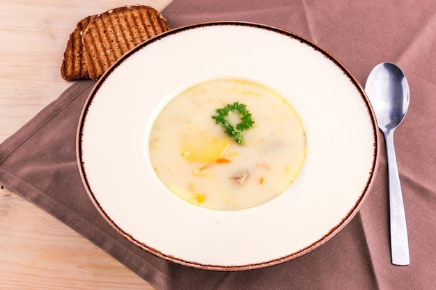 Sopa de queijo em um prato branco com pão torrado