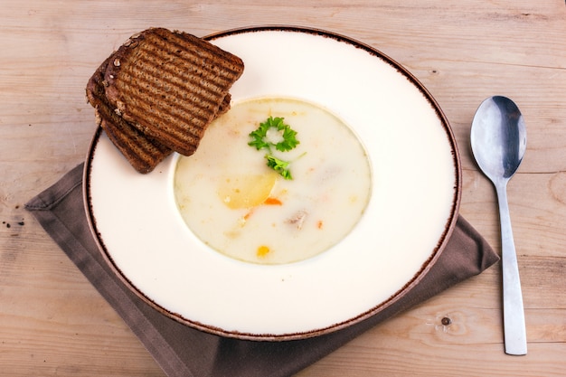 Sopa de queijo em um prato branco com pão torrado