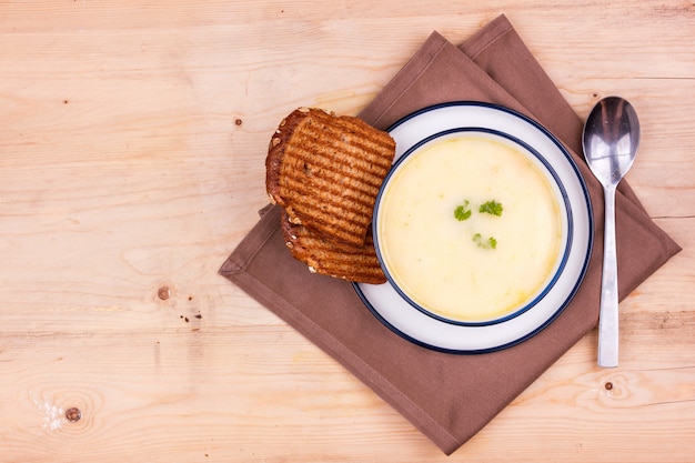 Sopa de queijo em um prato branco com pão torrado