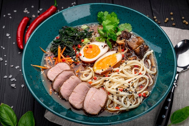 Sopa de ramen asiático com cogumelos de macarrão caseiro de carne e ovo em conserva