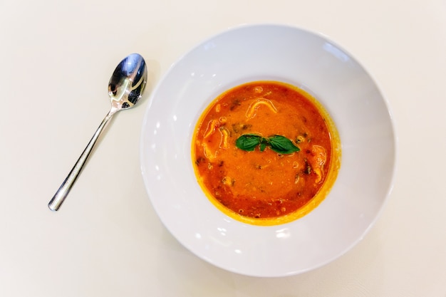 Sopa de ravioli com manjericão em tigela branca.