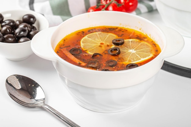 Sopa de solyanka com carne salsichas legumes picles azeitonas e limão