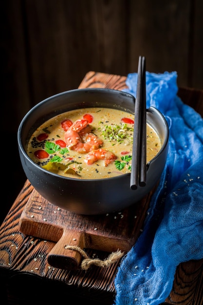 Sopa de Tom Yum com camarões em fundo escuro