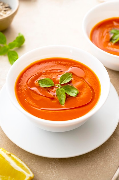 Sopa de tomate com manjericão fresco em tigelas brancas Fundo brilhante Sopa cremosa vegana