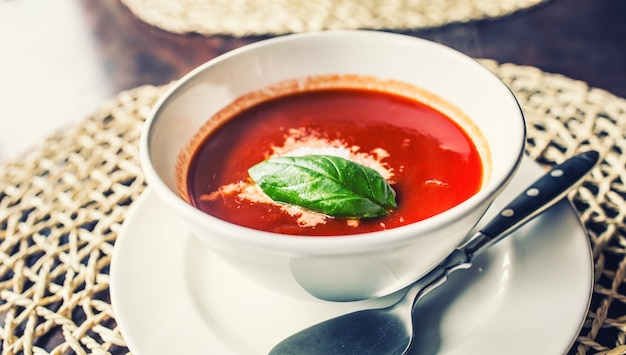 Foto sopa de tomate com queijo parmesão e manjericão deixa na mesa do restaurante.