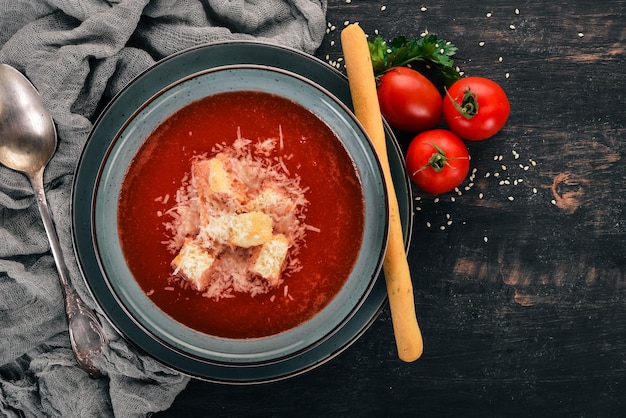 Sopa de tomate com queijo parmesão Em um fundo de madeira Vista superior Copie o espaço