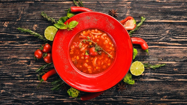 Sopa de tomate de frango de milho e pimenta vista superior em um fundo preto de madeira copie o espaço