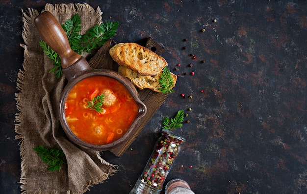 Sopa de tomate picante com almôndegas, massas e legumes. Jantar saudável.