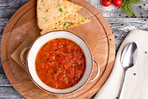 Sopa de tomate Sopa de tomate em uma vista superior de fundo branco de madeira