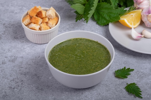 Sopa de urtiga de primavera e cebola selvagem limão e pão Comida vegana saudável