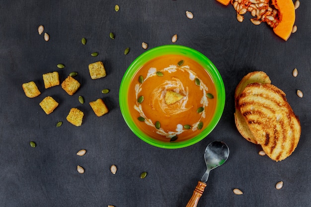 Sopa deliciosa da abóbora com na tabela de madeira. Comida vegetariana.