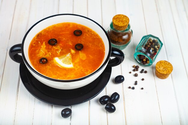 Sopa deliciosa em um prato. Carne Solyanka com azeitonas.