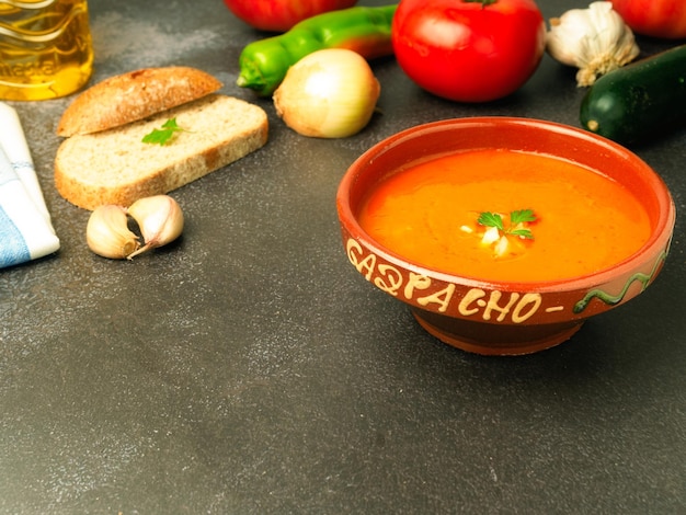 Foto sopa española fría gazpacho casero servido en un bol con verduras a su alrededor