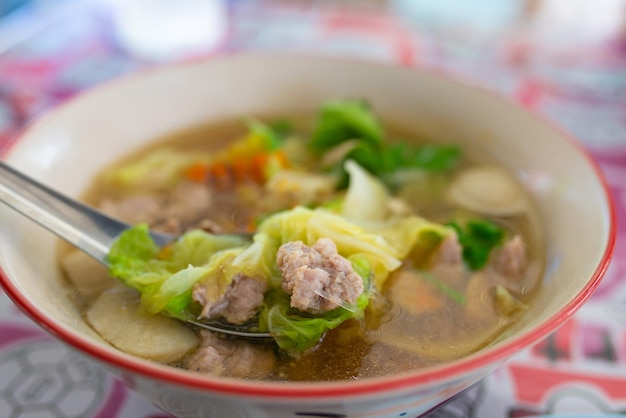 Sopa de estilo tailandés con carne de cerdo y verduras en un tazón