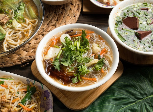 Sopa de fideos de arroz caliente servida en un plato aislado en la vista lateral de la mesa de la comida de taiwán