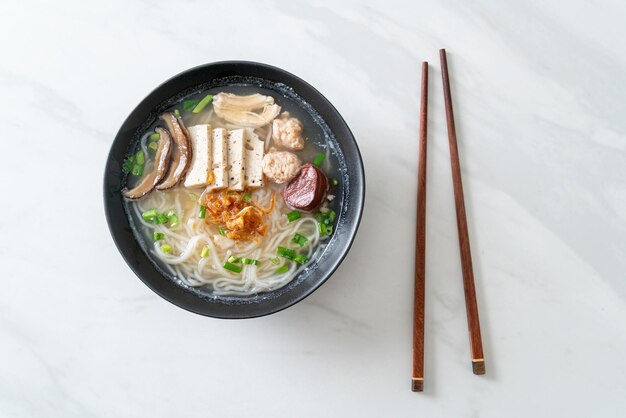 Sopa de fideos de arroz vietnamita con salchicha vietnamita servida con verduras y cebolla crujiente - Estilo de comida asiática