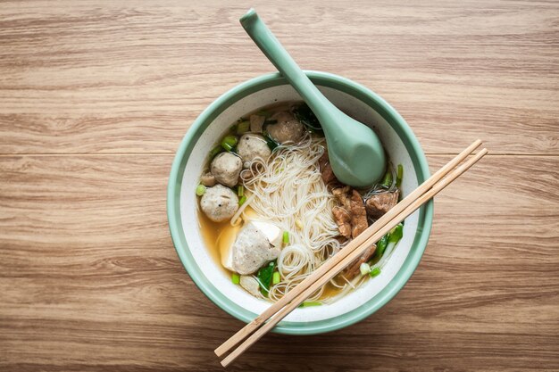 Sopa de fideos sopa de cerdo y tofu en un tazón con palillos