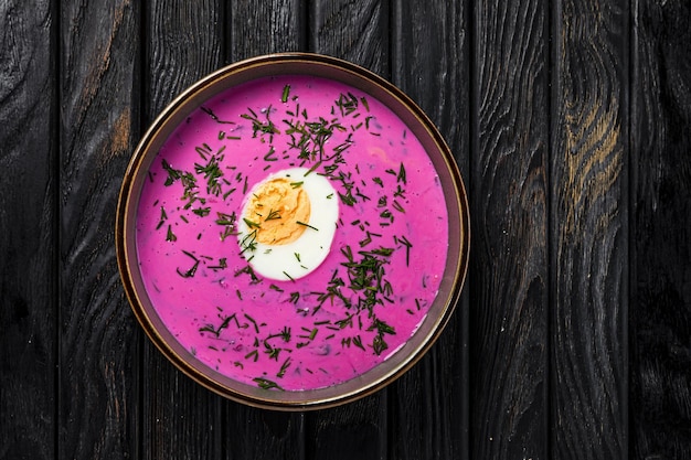 Sopa fria de borscht com ovo cozido na mesa de madeira, um tiro de cima