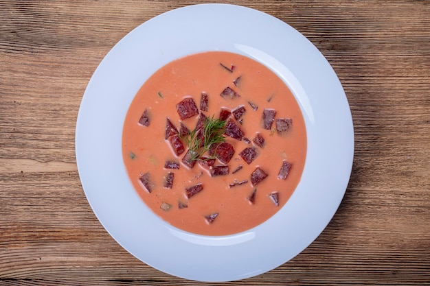 Sopa fría de remolacha con verduras en primer plano de la mesa de madera