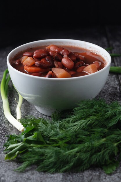 Sopa de frijoles con hierbas en un tazón blanco