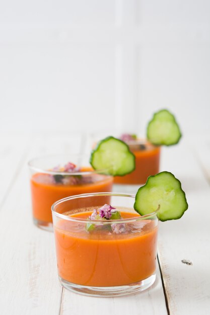 Sopa de gazpacho en vidrio sobre mesa de madera