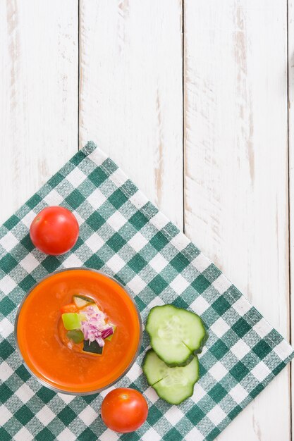 Sopa de gazpacho en vidrio sobre mesa de madera