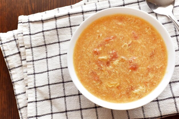 Foto sopa de gotas de huevo de tomate en un tazón blanco