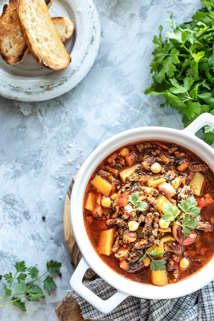 Sopa grossa de carne picada com tomate, feijão, grão de bico e legumes.