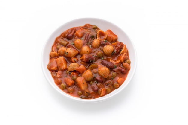 Sopa de guisantes de granos vegetales de pasta en salsa de tomate sobre fondo blanco aislado