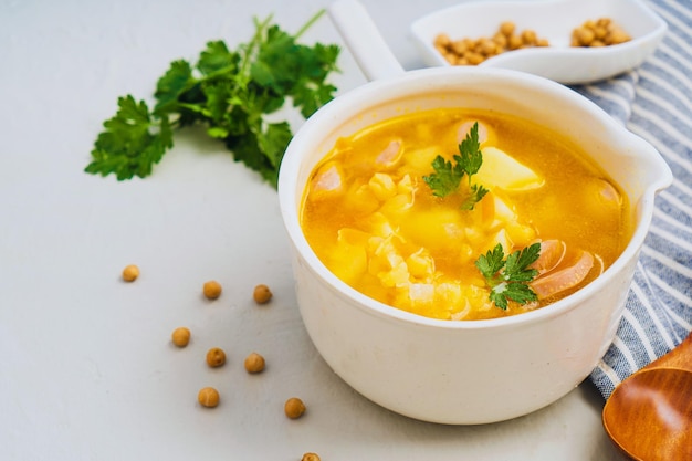 Sopa de guisantes sabrosa tradicional con salchicha ahumada servida en un tazón blanco