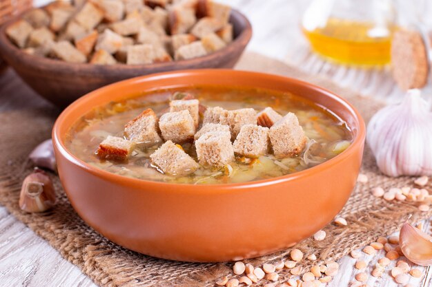 Sopa de guisantes tradicional casera con picatostes en el fondo de la tabla. Estilo rústico