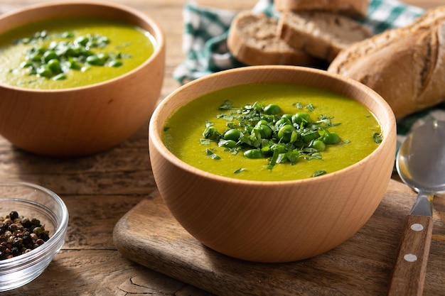 Sopa de guisantes verdes en un cuenco de madera