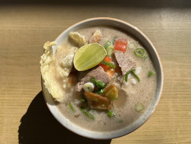 Foto sopa indonésia chamada soto tangkar com biscoitos de limão carne de alho-poró e batata