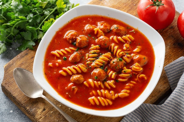 Sopa italiana de tomate com macarrão e almôndegas servida no prato.