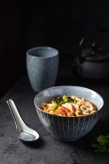 Sopa japonesa con anguila frita Yanagawa Nabe en un bol de fondo oscuro