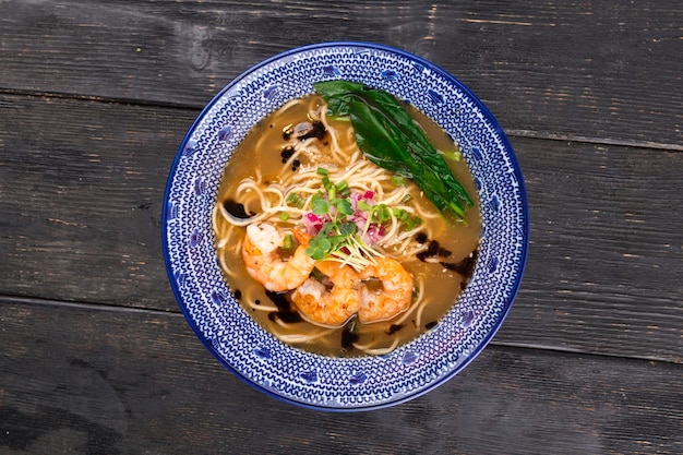 Sopa japonesa de macarrão ebi ramen com camarões tigre na mesa de madeira