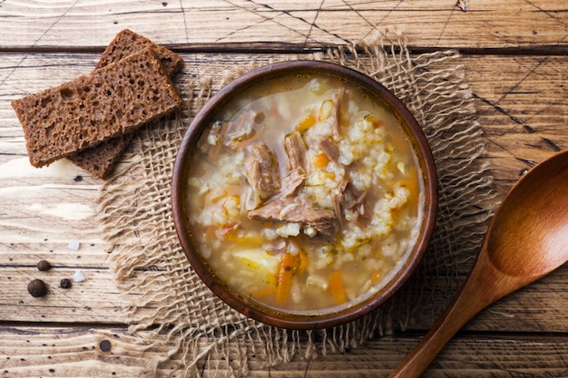 Foto sopa kharcho con carne y arroz en mesa de madera