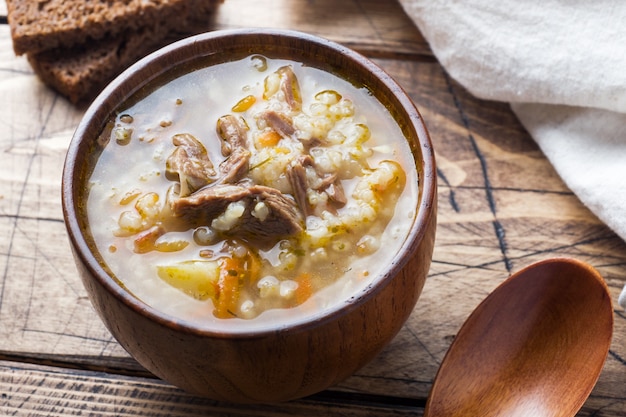 Sopa Kharcho com carne e arroz na mesa de madeira