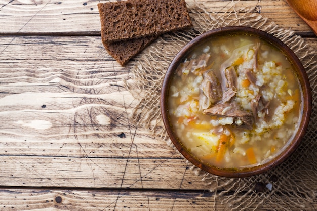 Sopa Kharcho com carne e arroz na mesa de madeira