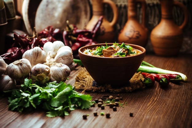 Sopa kharcho con perejil fresco sobre un fondo de madera con verduras frescas cebollas y ajo Sopa de carne tradicional georgiana