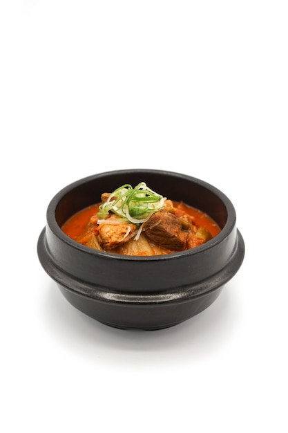 Sopa de kimchi aislado en el cuenco de piedra negra