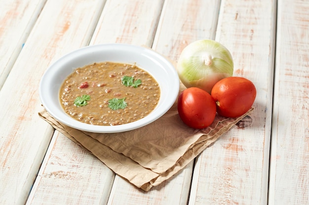 Sopa de lentejas con ingredientes al lado plato casero saludable