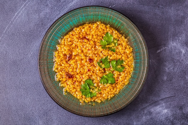 Sopa de lentejas en un plato adornado con perejil y especias