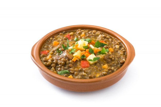 Sopa de lentejas en un recipiente aislado en blanco