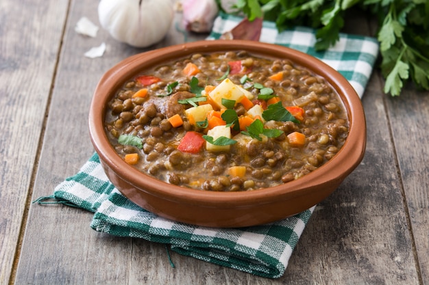 Sopa de lentejas en un tazón de madera