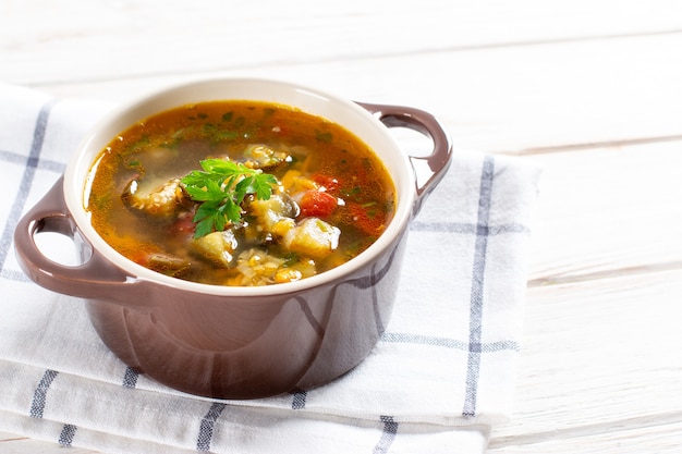 Sopa de lentejas y verduras en una mesa de luz. Lugar para el texto