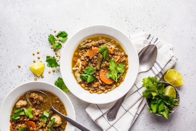 Sopa de lentejas con las verduras en una placa blanca, fondo blanco, visión superior. Comida a base de plantas, comida limpia.